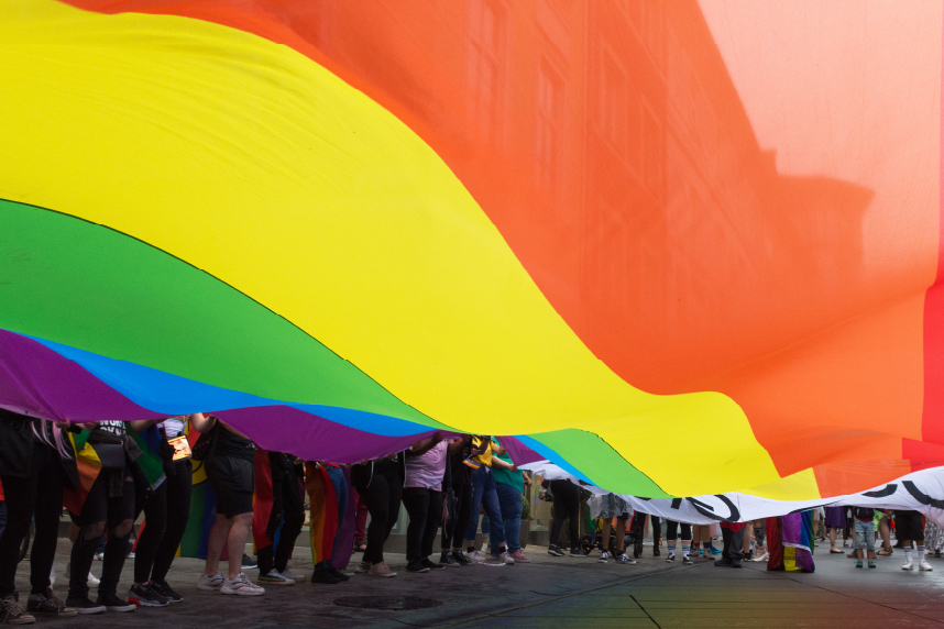 Underside photograph of people waving rainbow flag