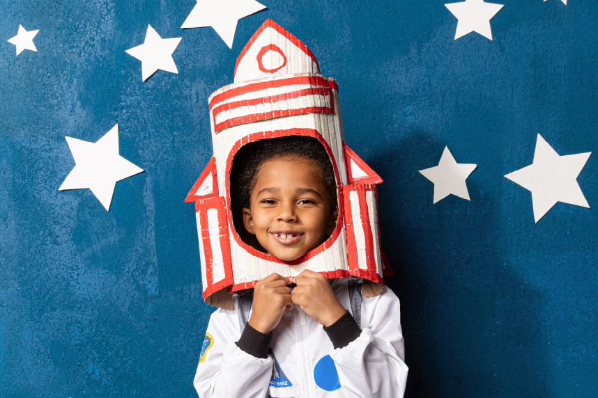 Little boy dressed as astronaut with rocket-shaped helmet