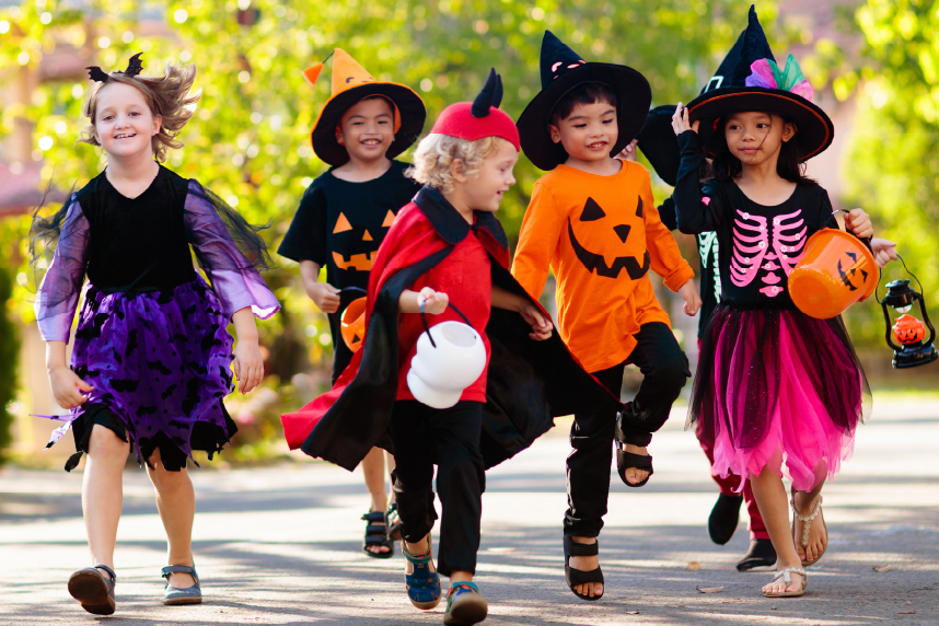 Children walking down a sidewalk in Halloween costumes
