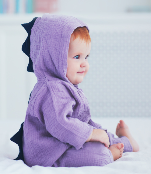 Infant dressed as purple dragon