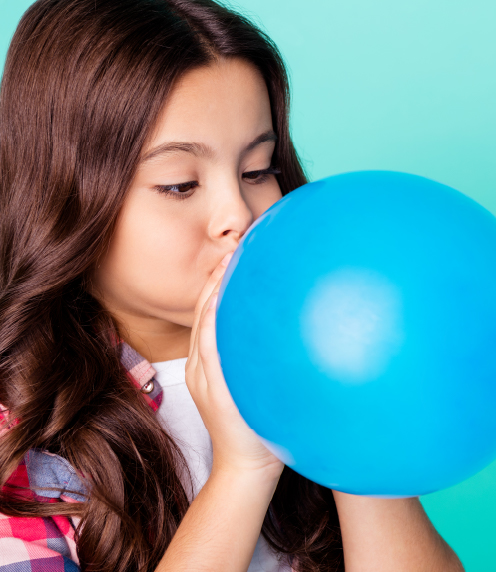 Young teenager blowing up a blue balloon