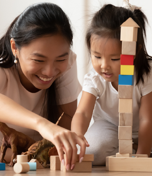 Mother and infant daughter building with wooden blocks
