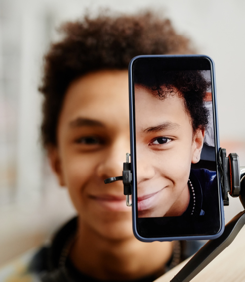 Teenage boy filming himself with a smartphone