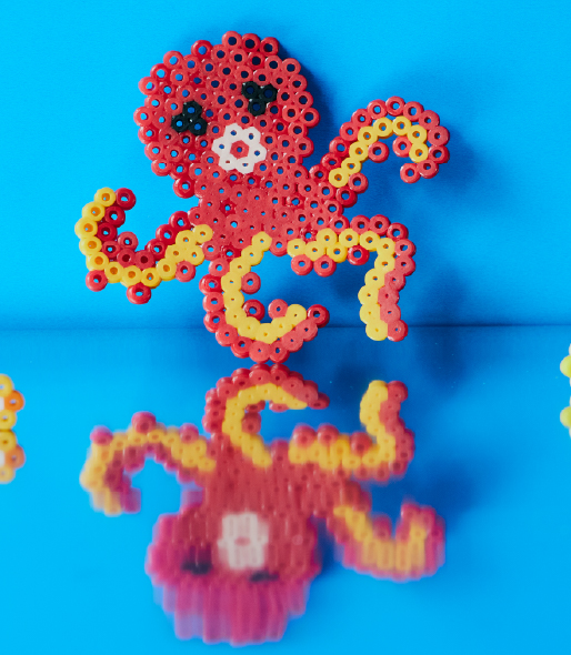 Octopus made of Perler beads on blue background