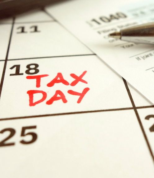 The words Tax Day written on the 18th on a calendar