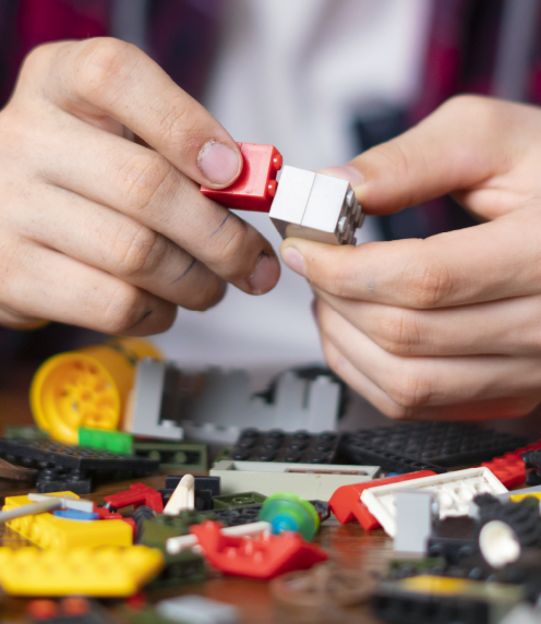 Close up of teenage boy's hands, putting together two Lego bricks