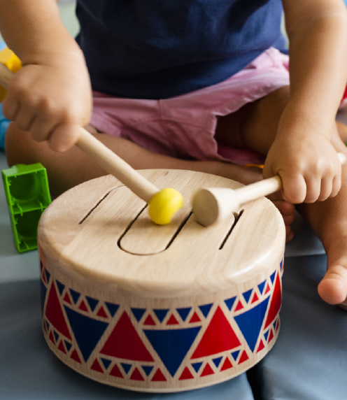 Toddler playing a small drum