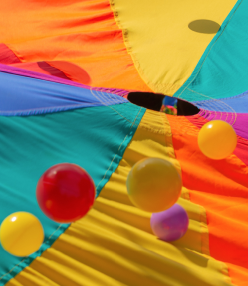 Balls bouncing on a colorful fabric parachute