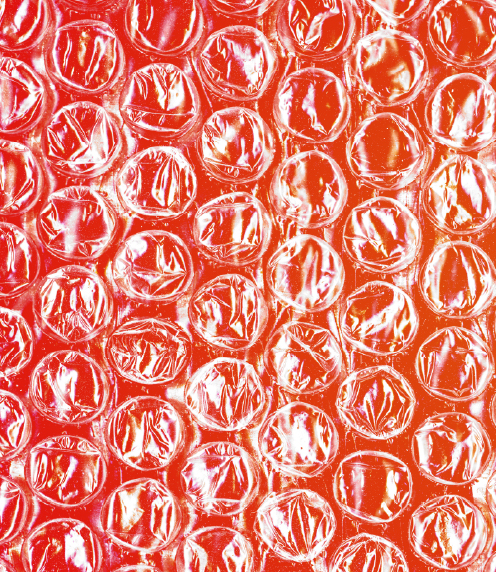Close up of bubble wrap over red background