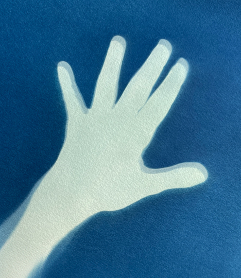 Silhouette of hand against blue background