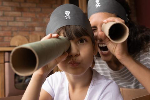 Mother and daughter using paper towel rolls as telescopes