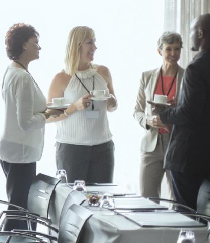 Group of people talking while holding coffee and tea cups