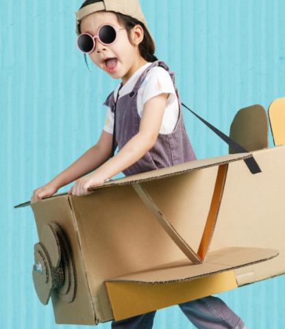 Little girl with cardboard, wearable airplane