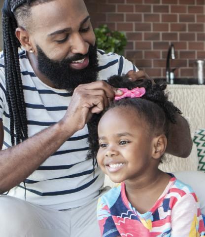 Father taking care of daughter's hair