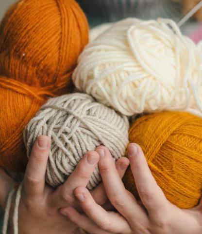 Teenager holding multiple skeins of yarn