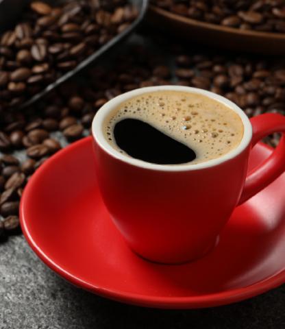 Red coffee cup with pile of coffee beans