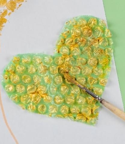 Heart cut out of bubble wrap, coated in yellow paint