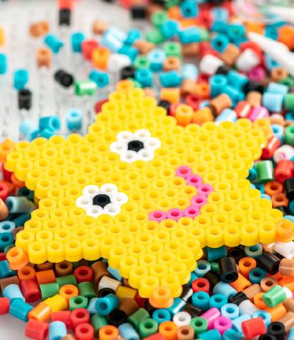 Star made of Perler beads on a pile of unfused Perler beads
