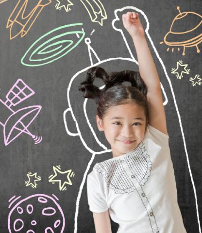 Young girl laying on chalkboard with astronaut suit outline around her