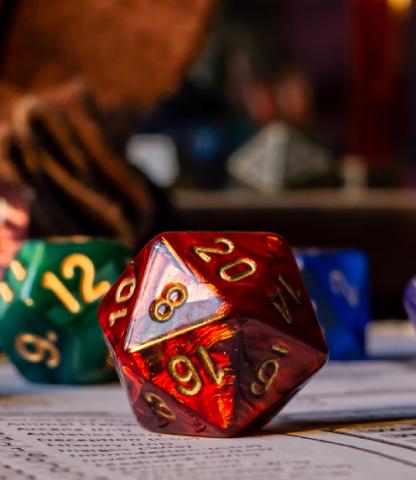 Close up of red twenty-sided dice with other dice in background