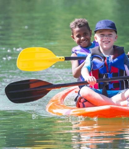 Two boys out on the water in a kayak