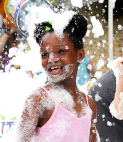 Little girl being blasted by foam