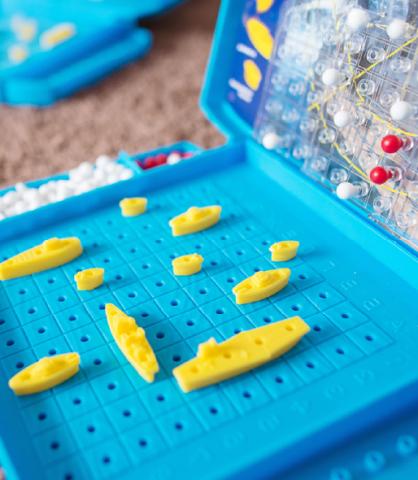 Close-up of yellow battleships on a blue game board