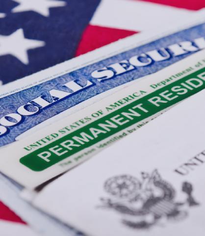 Close up of US Green Card and Social Security Card on US flag