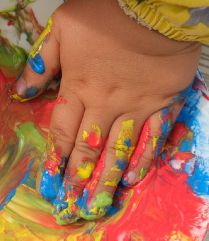 An infant hand covered in paint