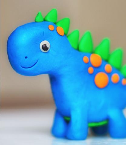 Blue dinosaur with orange spots and green spikes, made of clay