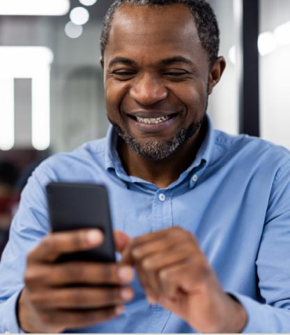 Black man using cellphone, smiling