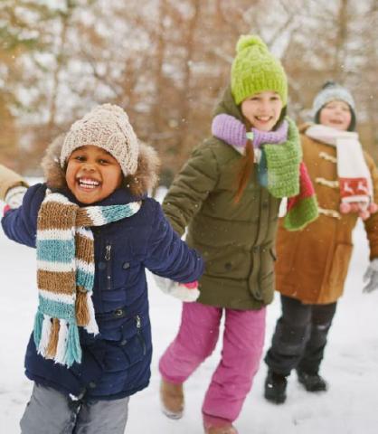 Three happy children outside in the winter