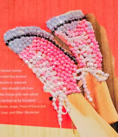 Close up of a book cover featuring a pair of pink Converse sneakers covered in rhinestones