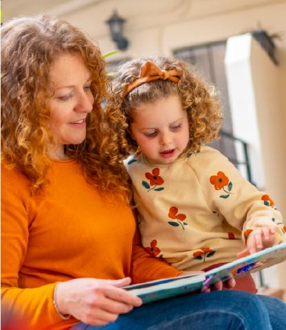 Mother and daughter reading book together