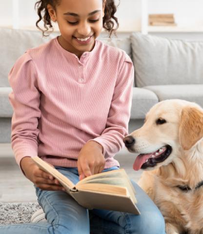 Young girl reading to dog