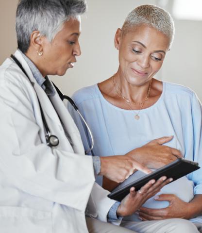 Mature woman and her doctor looking at information on a tablet