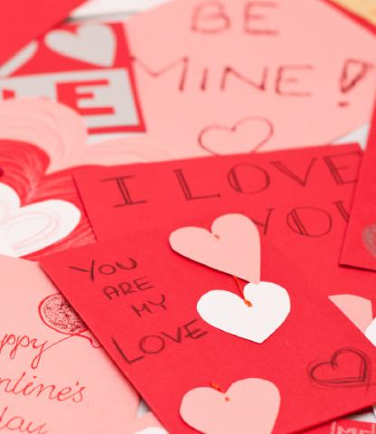 Close up of scattered Valentine's Day cards in red, white, and pink