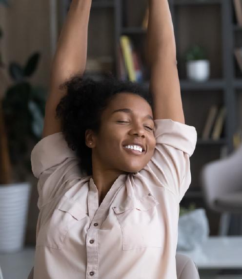 Young woman stretching at office desk