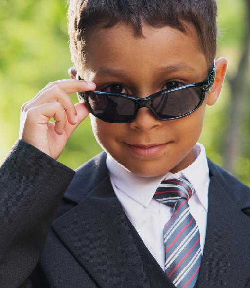 Young boy in suit with tie, looking over the top of his sunglasses