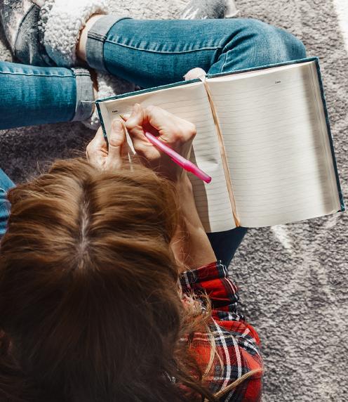 Overhead photo of young woman writing in a journal