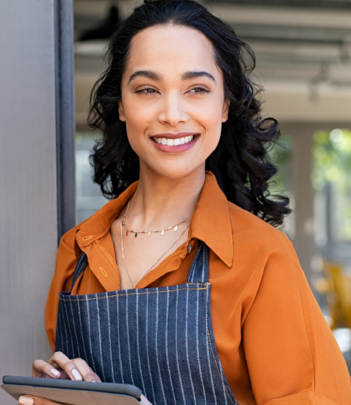 Woman in a chef's apron outside a cafe