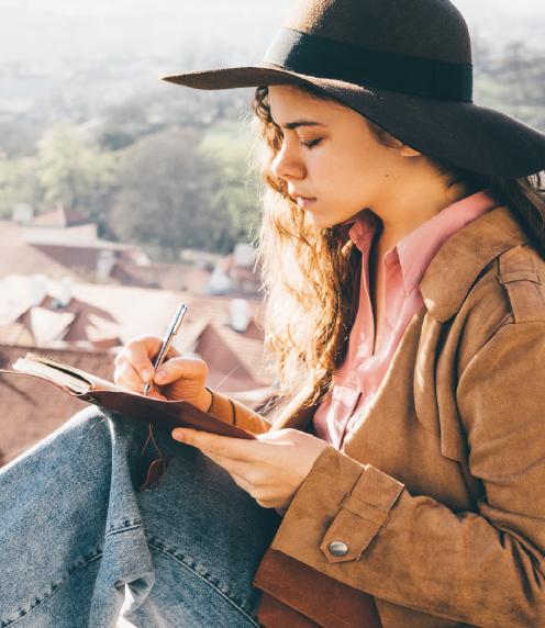 Young woman writing outside