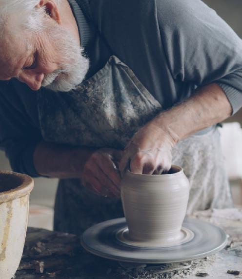 Senior man using a potter's wheel to create a vase