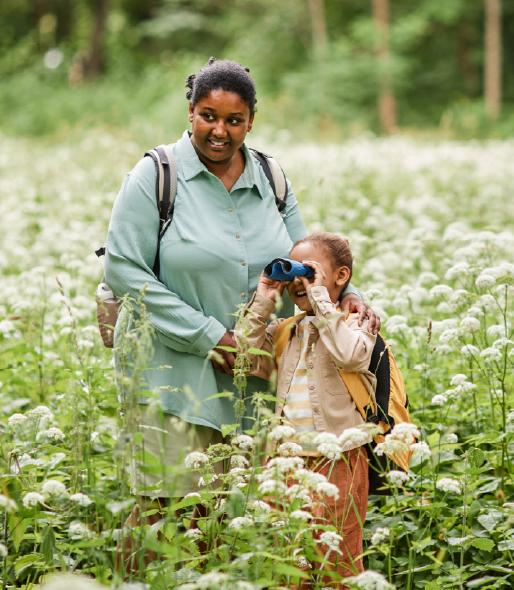 Mother and daughter out in a field with binoculars