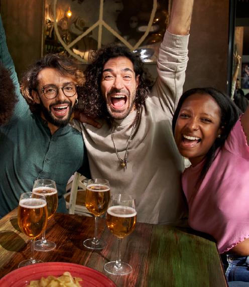 Three young adults celebrating at a bar