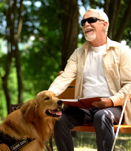 Senior blind man sitting outside with guide dog