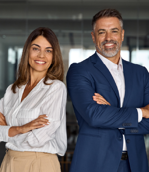 A man and woman in business attire smiling at the camera