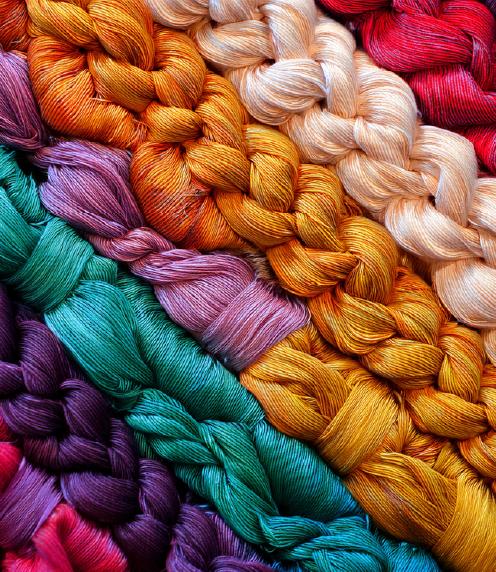 Several hanks of a colorful, braided yarn laying diagonal