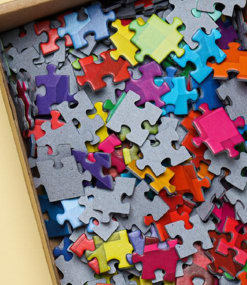 Close up of a cardboard box containing colorful puzzle pieces