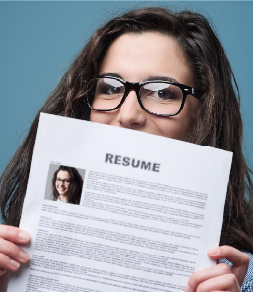Young woman holding her resume up in front up her